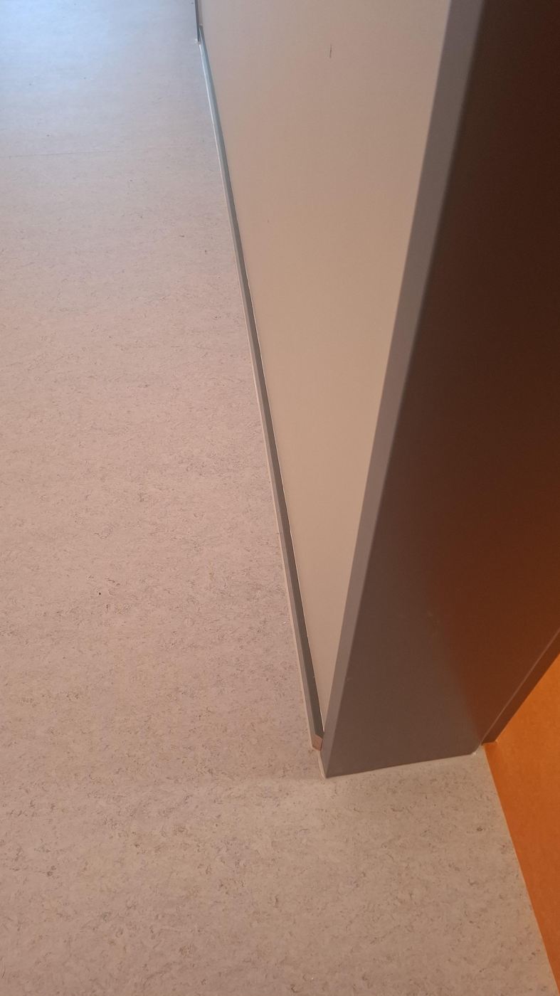 Fertiger Schulraum mit orangefarbenem Linoleum und schwarzer Sockelleiste