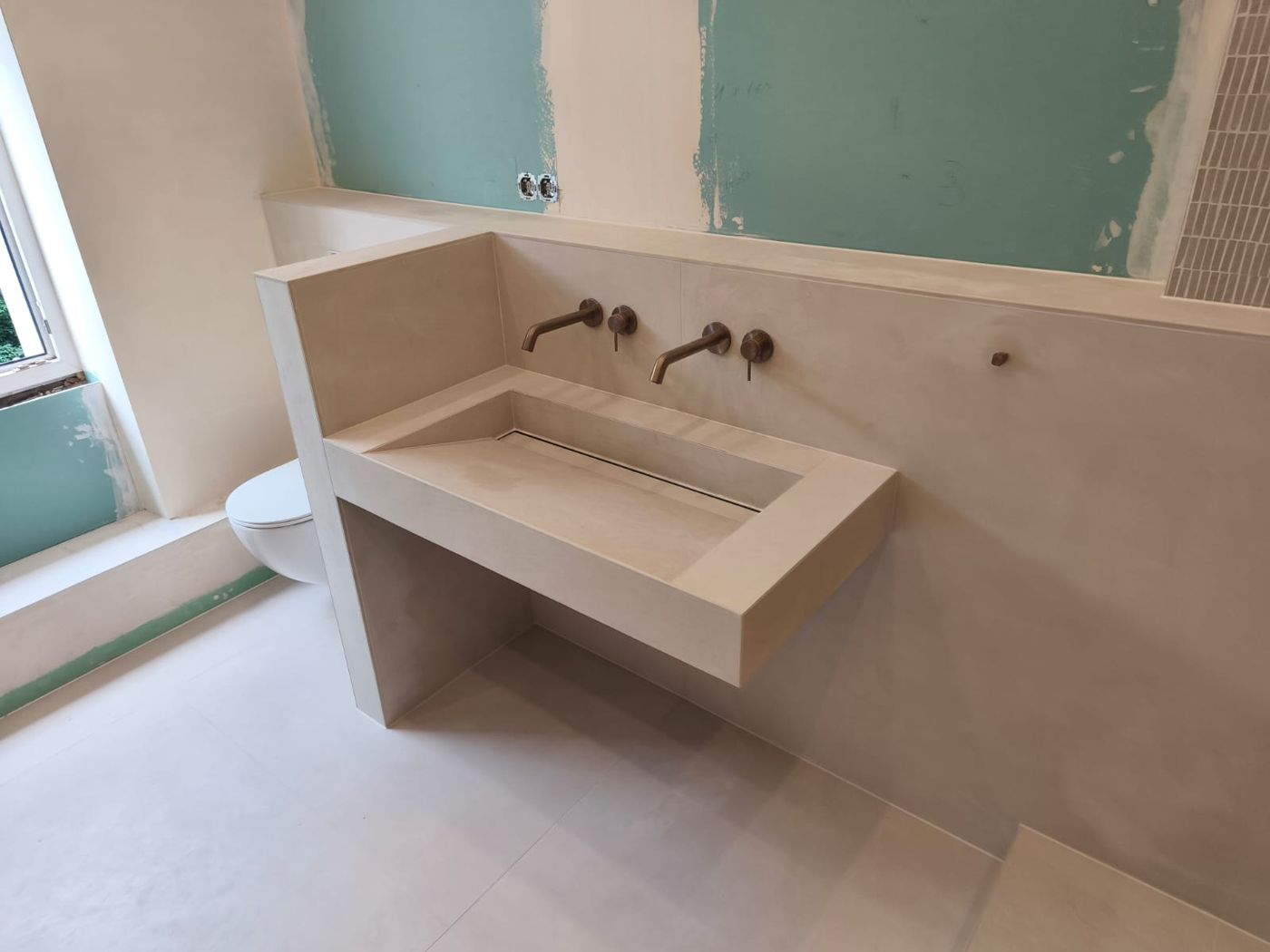 Fugenloser Waschtisch in Betonoptik mit Wandarmaturen