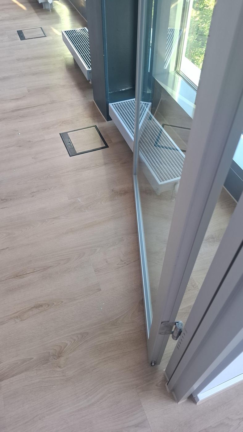 Designbelag an Glasfaltwand mit Bodentanks und Konvektoren angearbeitet